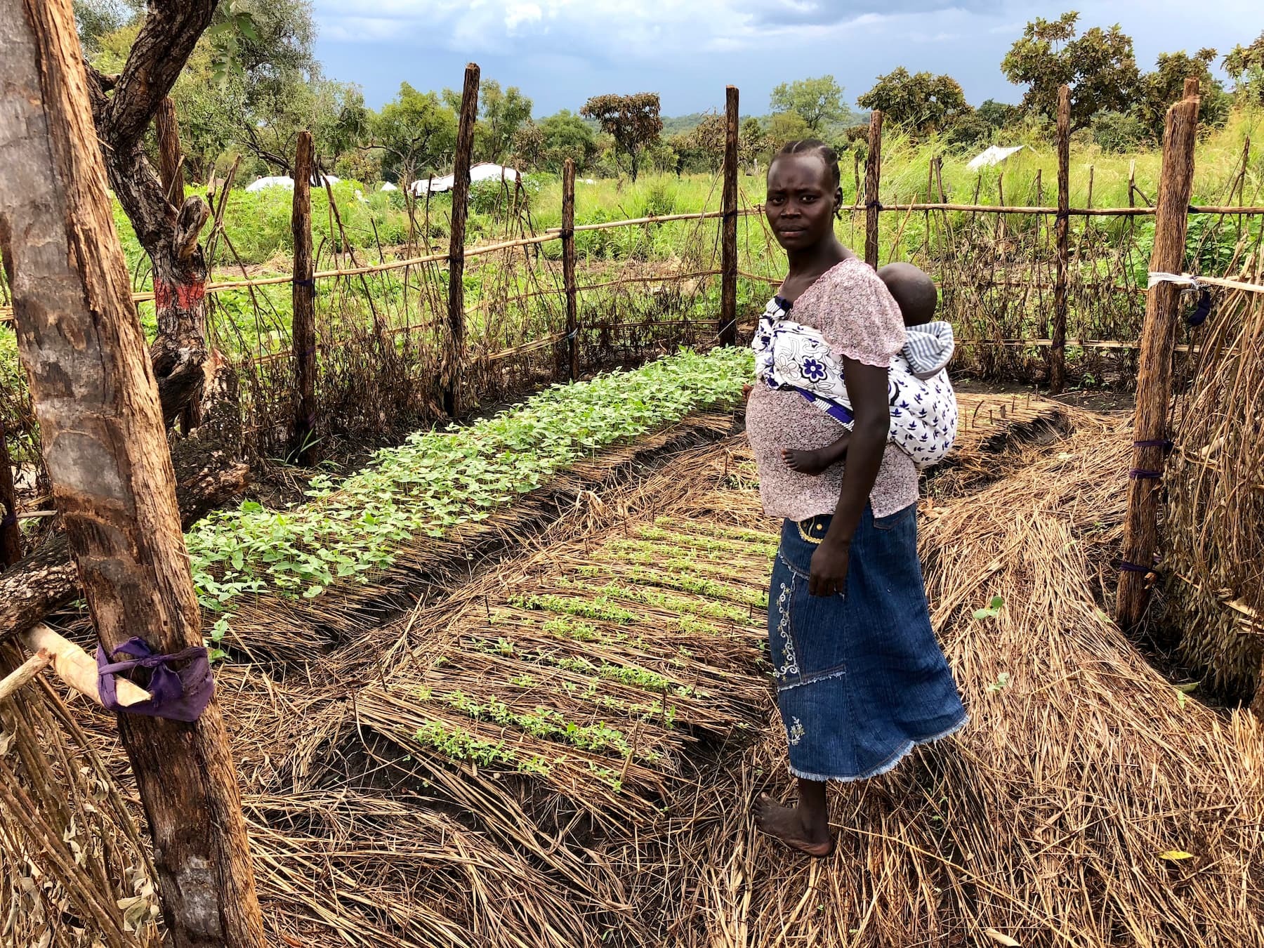 Woman and child standing inside a permagarden